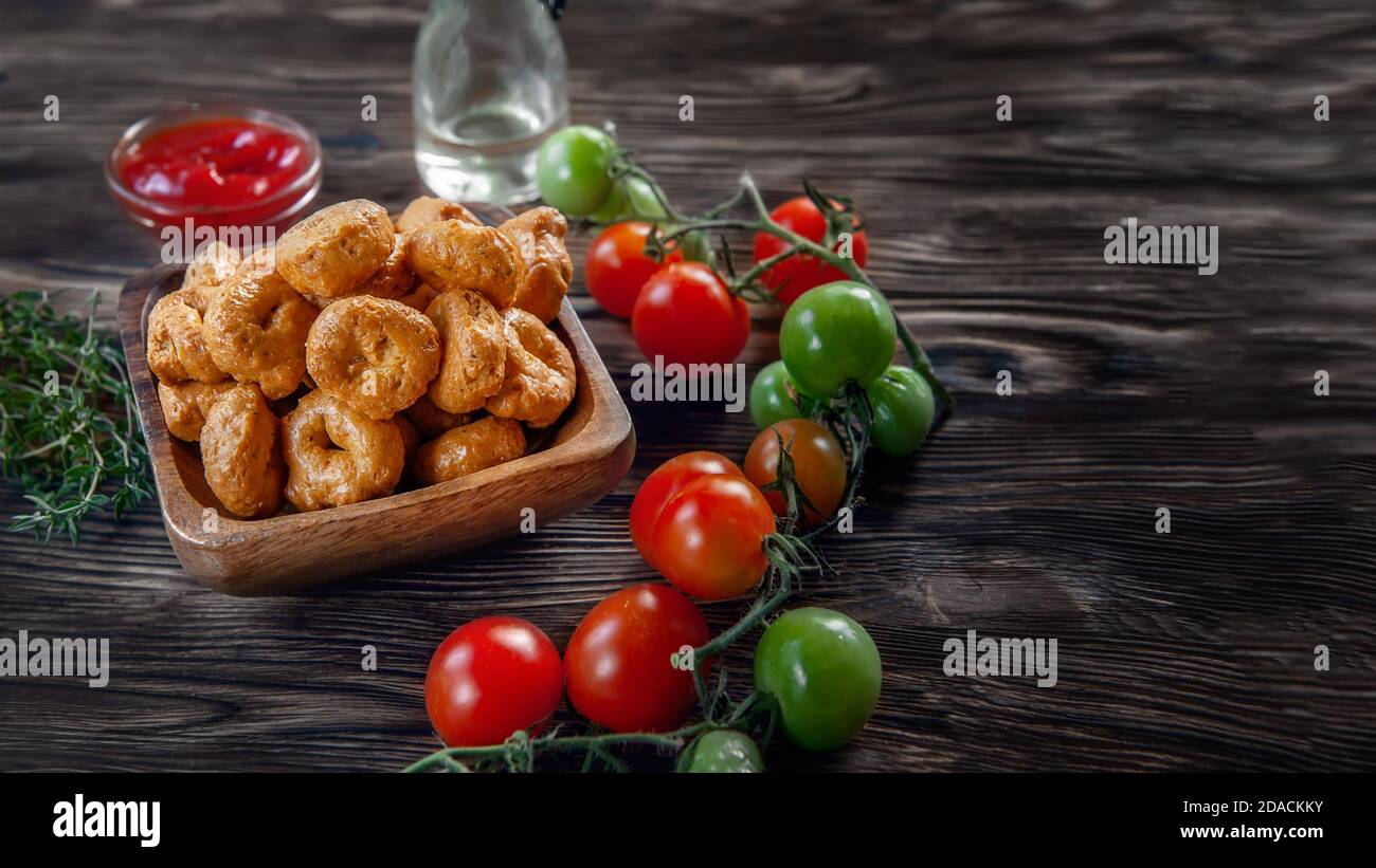 Tarallini fait main avec des tomates et des herbes est appelé taralli ou TALRALLINI. Produits dans les boulangeries italiennes du sud de l'Italie. Petits anneaux à grignoter sur un Banque D'Images