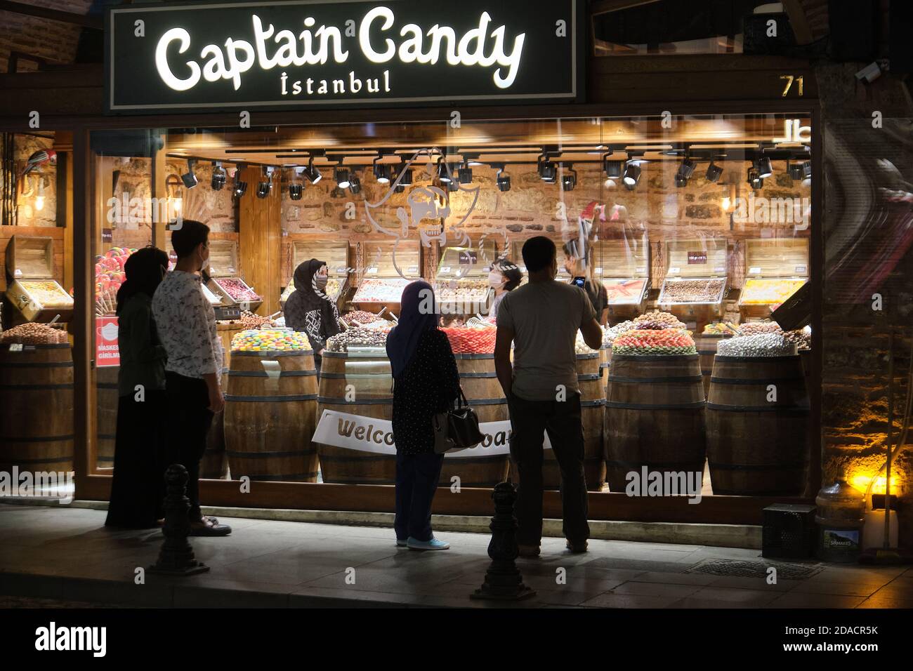 Les clients qui ont des masques de visage à l'intérieur et à l'extérieur regardent des bonbons dans un magasin Captain Candy, Istanbul, Turquie Banque D'Images