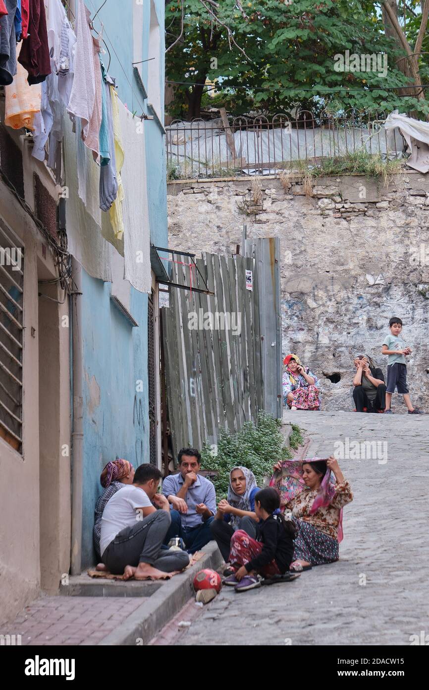 Des membres de la famille assis à l'extérieur dans une rue à Balat partageant des collations, Istanbul, Turquie Banque D'Images