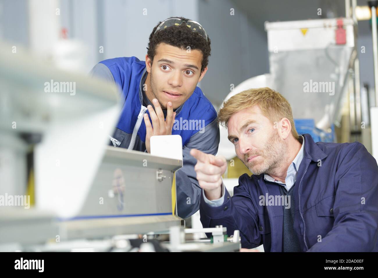 Deux hommes travaillant sur une machine Banque D'Images