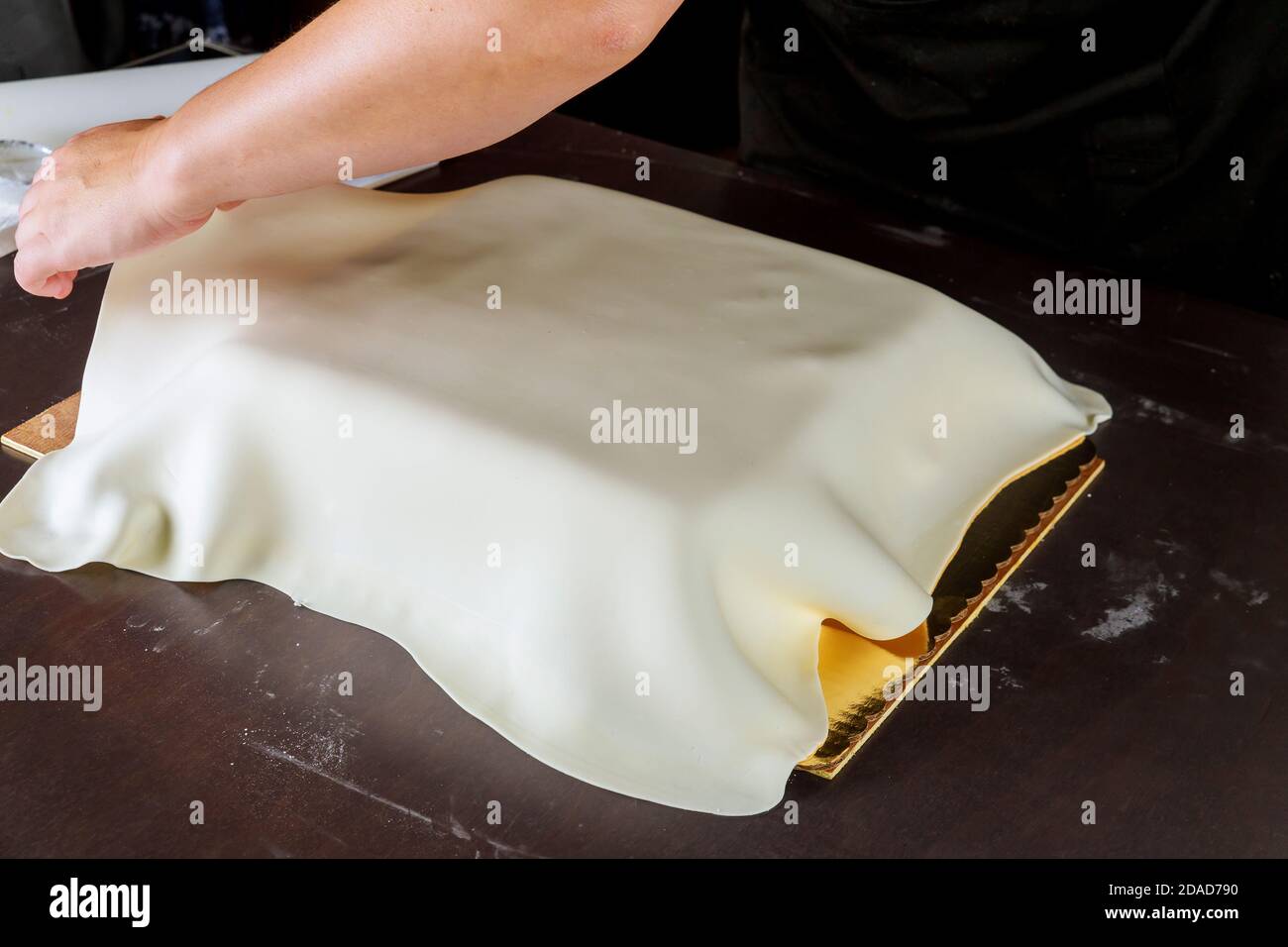 Femme faisant du gâteau avec fondant pour la fête. Technique du boulanger. Banque D'Images