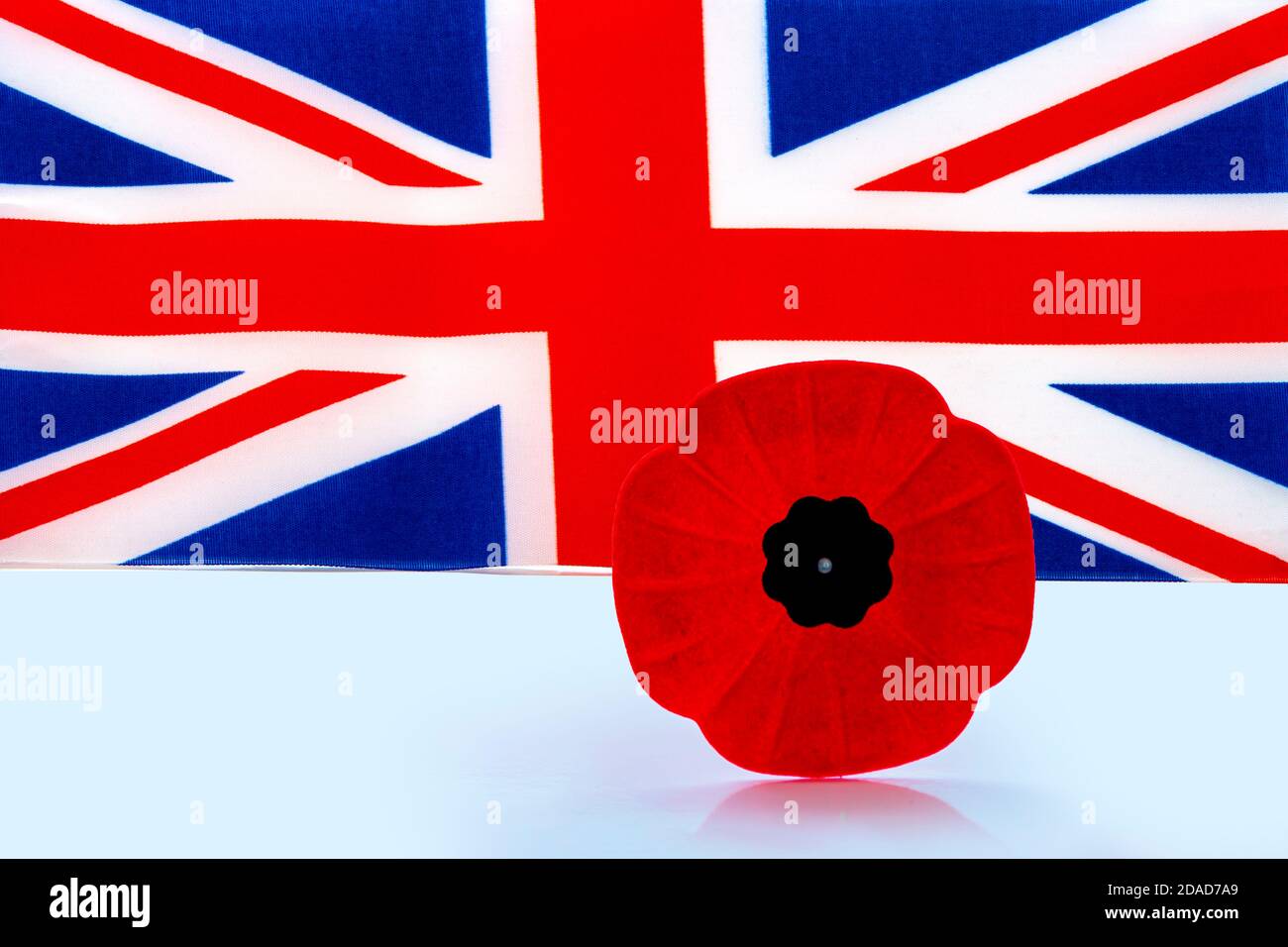 Une fleur de pavot du jour du souvenir avec un drapeau britannique sur le fond. Banque D'Images