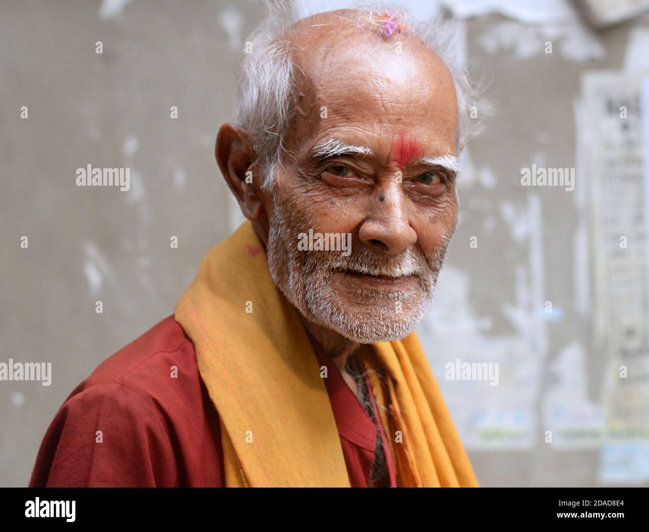 Ancien prêtre indien du temple hindou / pèlerin avec la marque rouge tilak sur son front élevé pose pour la caméra pendant le festival religieux Navratri. Banque D'Images