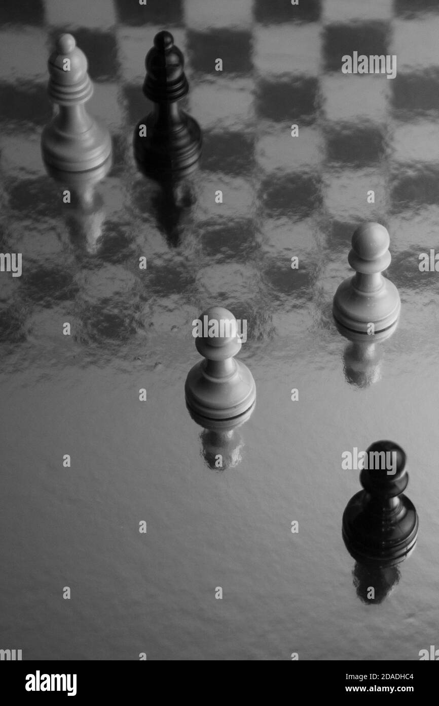 Photographie de pièces d'échecs noir et blanc. Jeu de stratégie. Pions avec réflexions sur l'arrière-plan original Banque D'Images