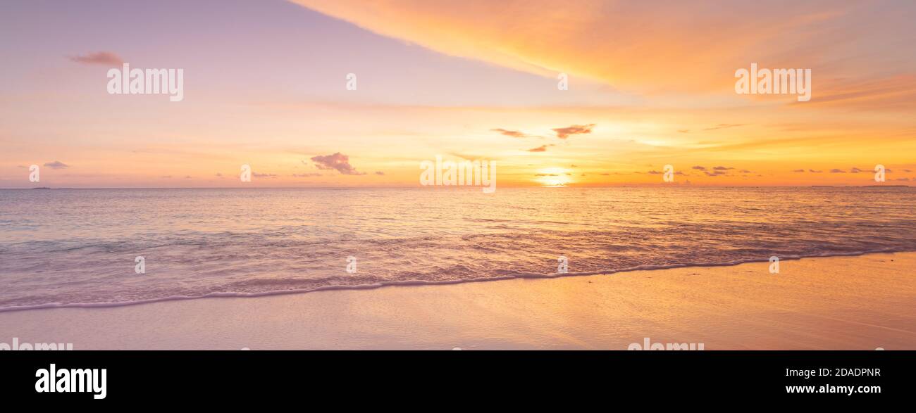 Magnifique coucher de soleil sur la plage et la mer. Plage tropicale au beau coucher du soleil. Arrière-plan de la nature. Paysage exotique, littoral, côte, vagues calmes, sable doux Banque D'Images