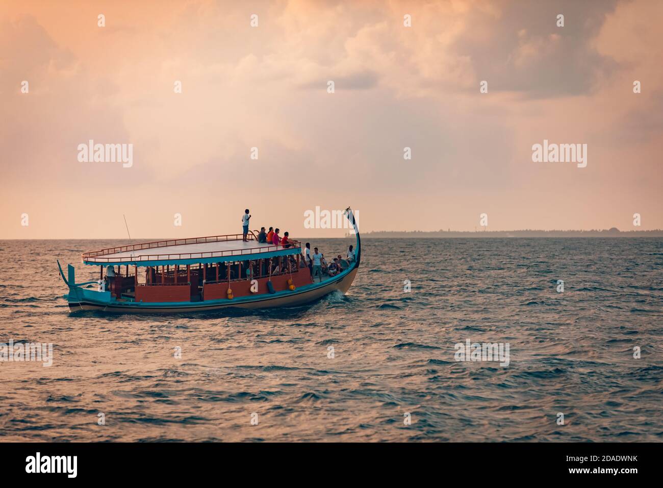 08.13.19 - atoll de Faafu, Maldives: Magnifique bateau maldivien Dhoni sur la mer bleue tropicale, prenant le touriste à une croisière au coucher du soleil. Personnes appréciant le coucher du soleil Banque D'Images