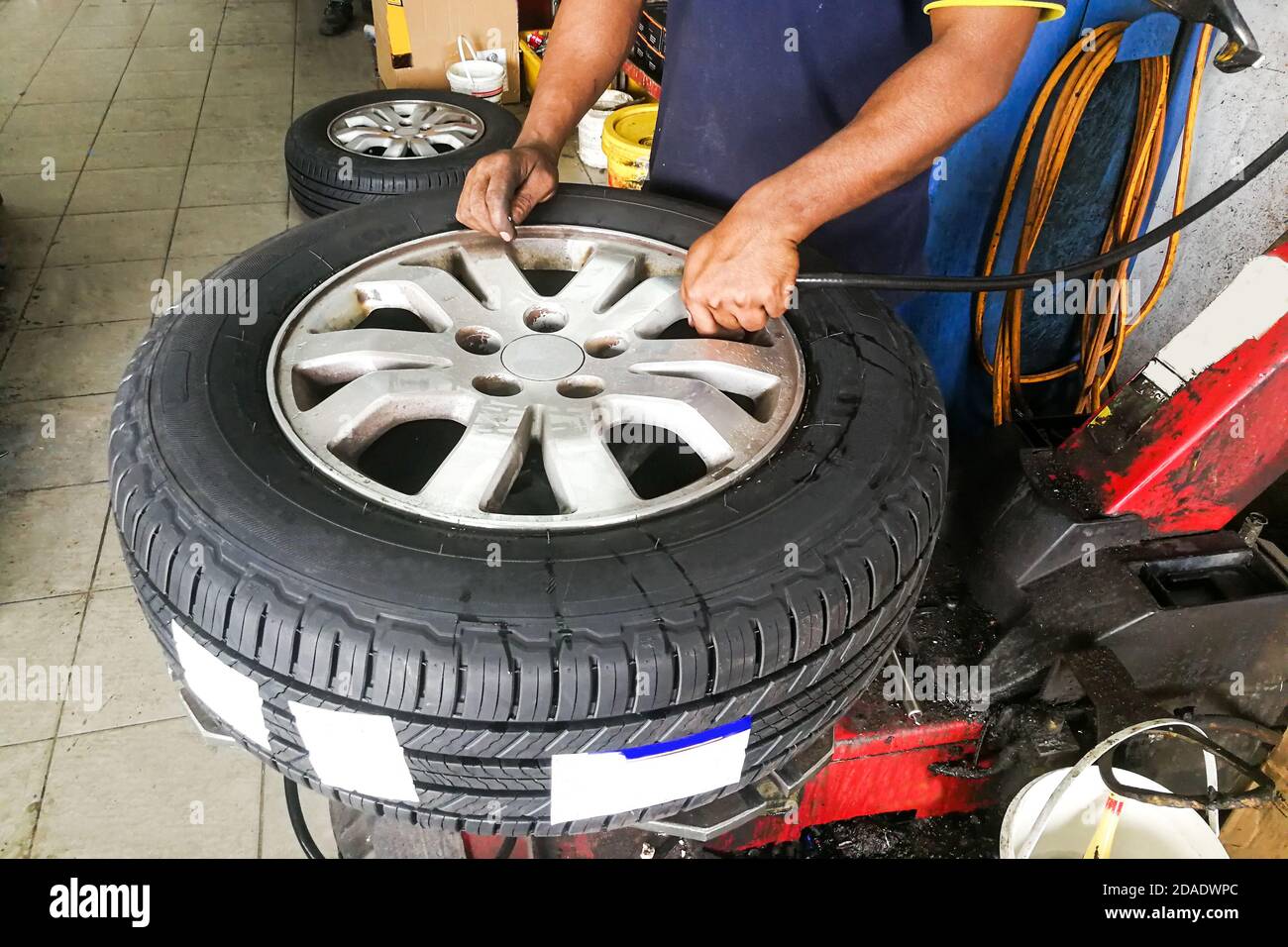 Série de techniciens effectuant l'équilibrage des pneus de roue de voiture Banque D'Images