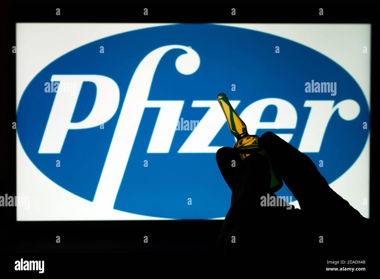 Société pharmaceutique Pfizer de vaccins contre le coronavirus. Logo Pfizer avec vaccin à main. Banque D'Images
