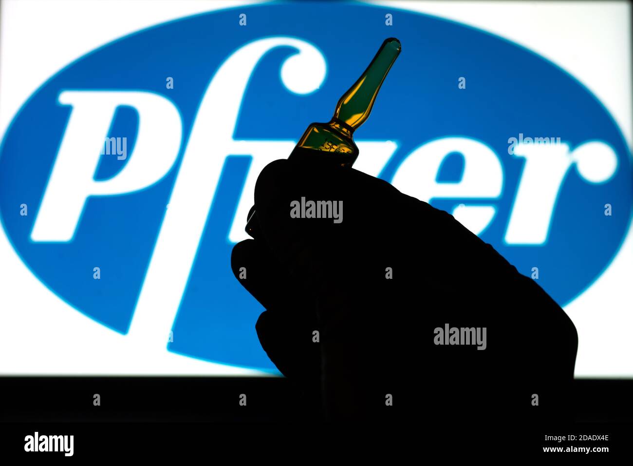 Société pharmaceutique Pfizer de vaccins contre le coronavirus. Logo Pfizer avec vaccin à main. Banque D'Images