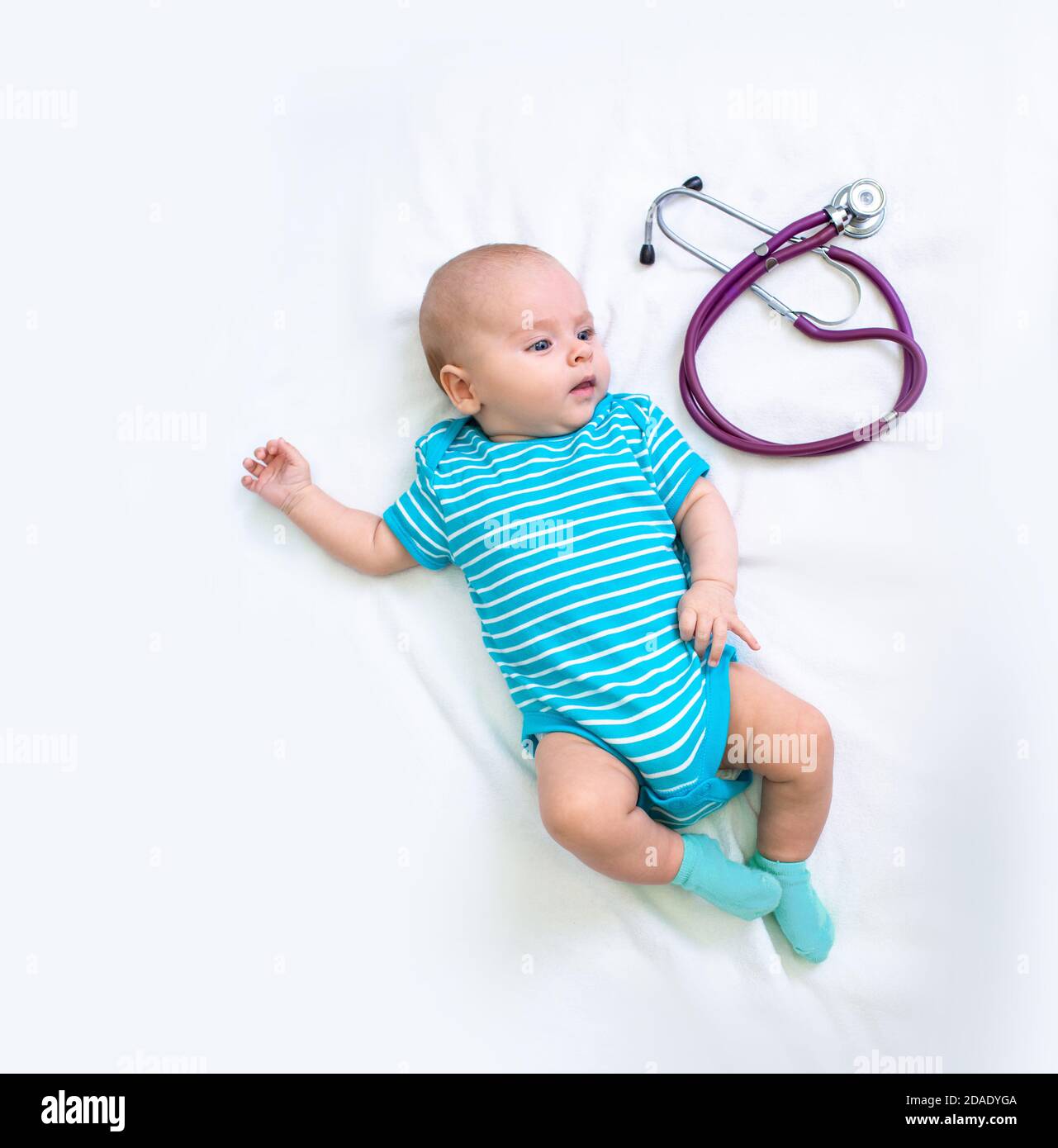 Nouveau-né le petit-né repose sur un lit blanc près du stéthoscope avant de voir un pédiatre. Prendre soin de la santé d'un enfant à la clinique Banque D'Images