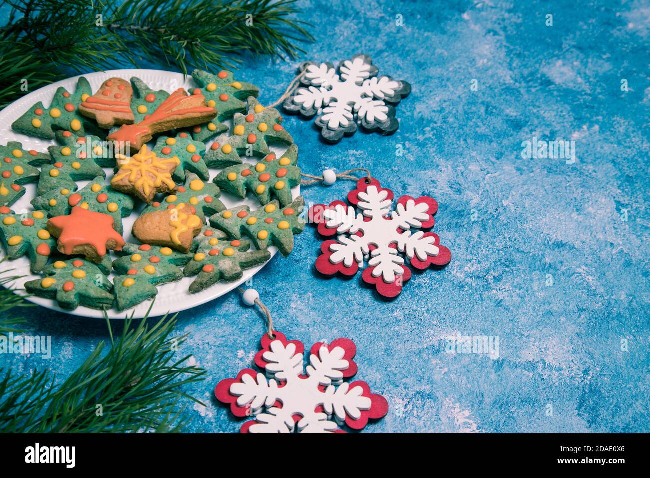 Assiette avec gâteaux faits maison de Noël et décorations de Noël sur fond bleu. Orientation horizontale. Copier l'espace Banque D'Images