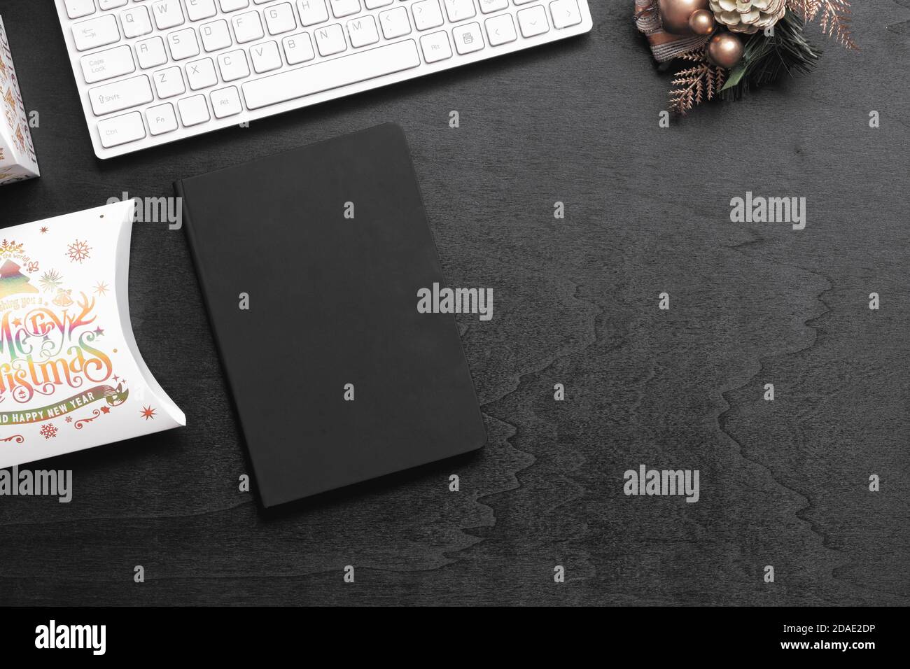 Vue de dessus de la couverture noire vierge carnet sur bois noir maison bureau arrière-plan avec décorations de Noël et boîte cadeau de Noël. Sous-groupe de Noël Mockup Banque D'Images