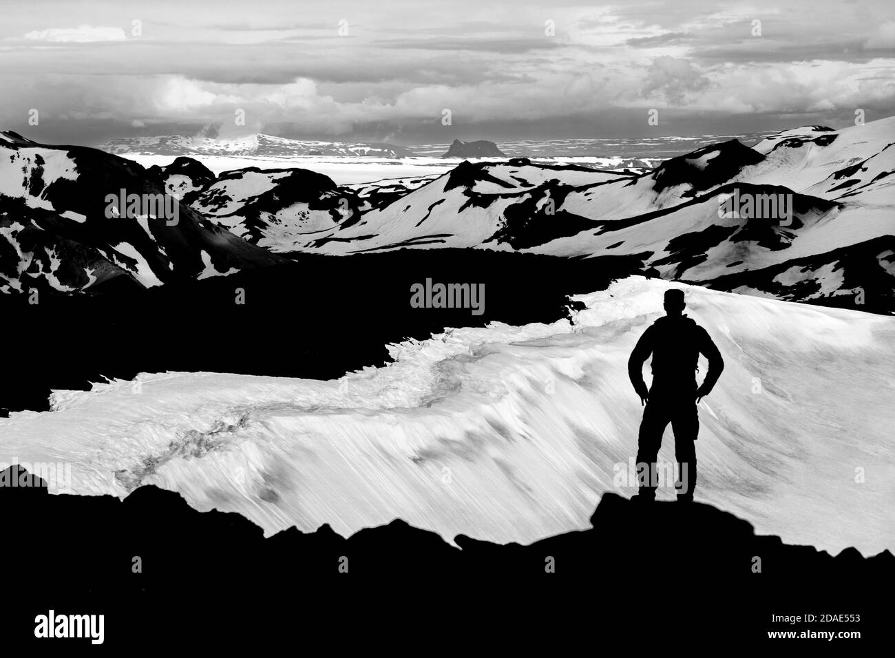 Hiker Man Silhouette bénéficiant d'une vue depuis le cratère d'OK Vulcano jusqu'aux montagnes enneigées de Thorisdalur. Monochrome, noir et blanc, Islande. Banque D'Images