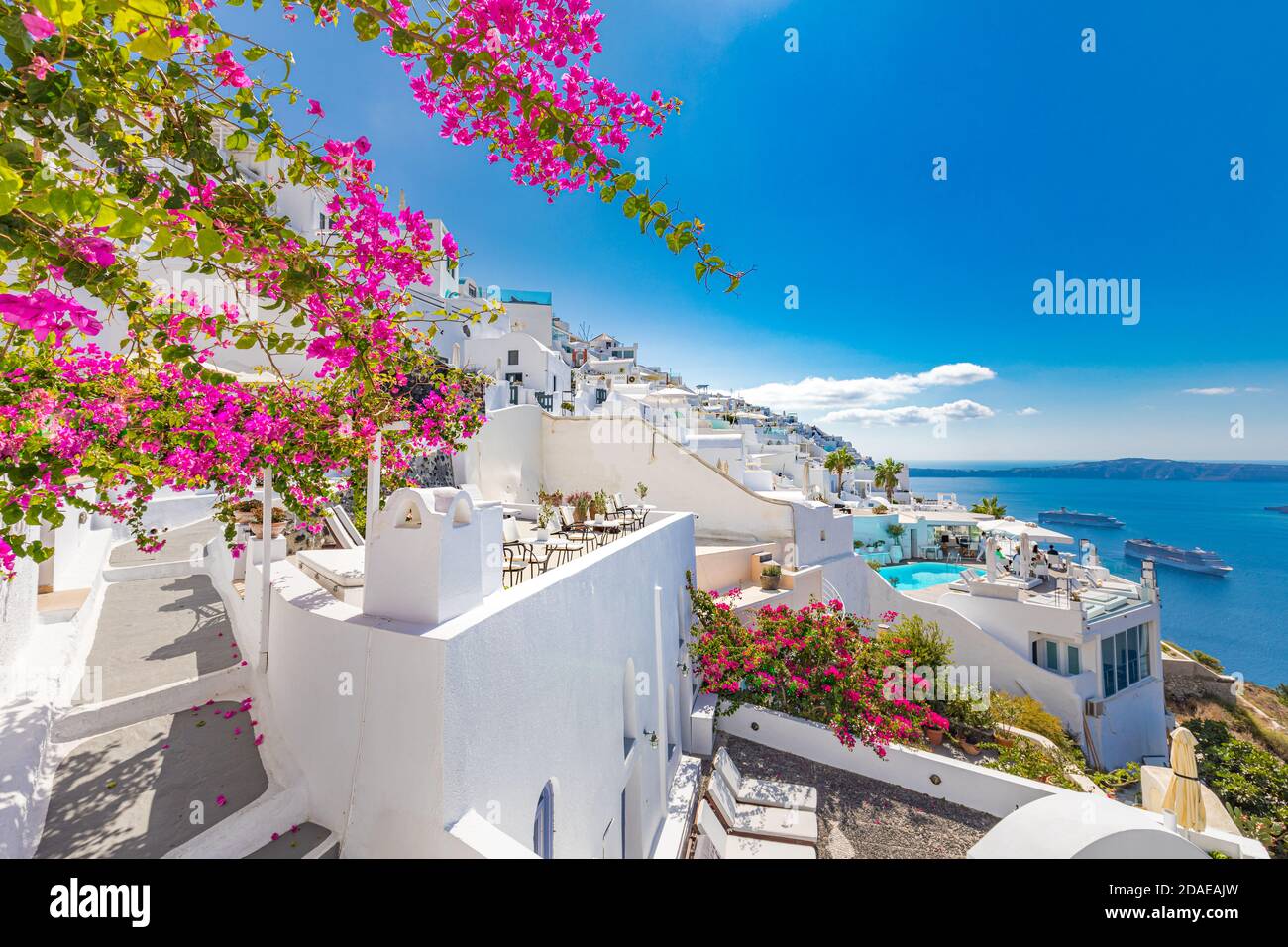 Les maisons bleues blanches traditionnelles célèbres fleurissent par temps ensoleillé au-dessus de la caldeira, mer Égée. Magnifique paysage d'été, vue sur la mer, voyage de luxe Banque D'Images