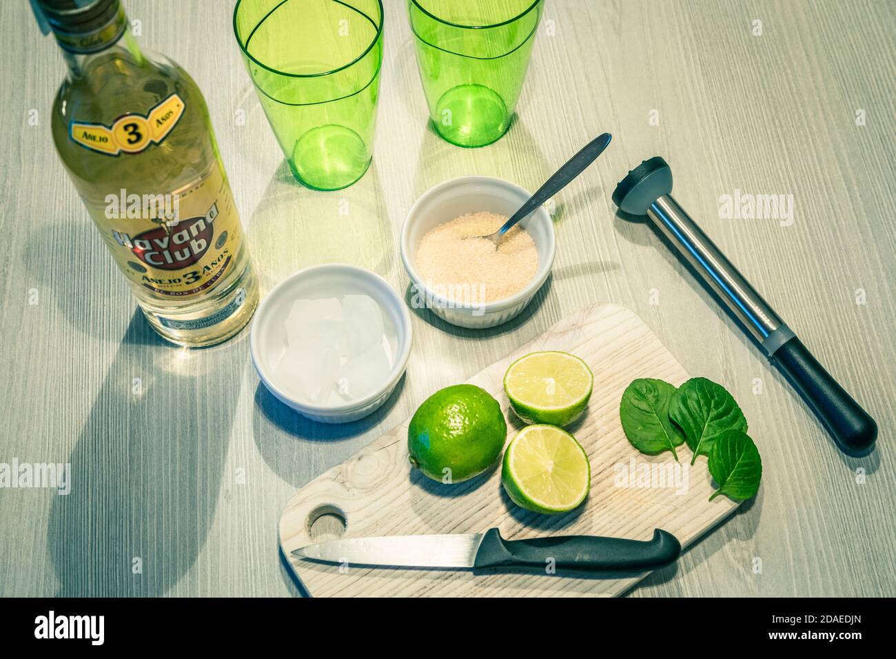 préparation d'un cocktail mojito, ingrédients sur une table en bois et quelques verres verts Banque D'Images