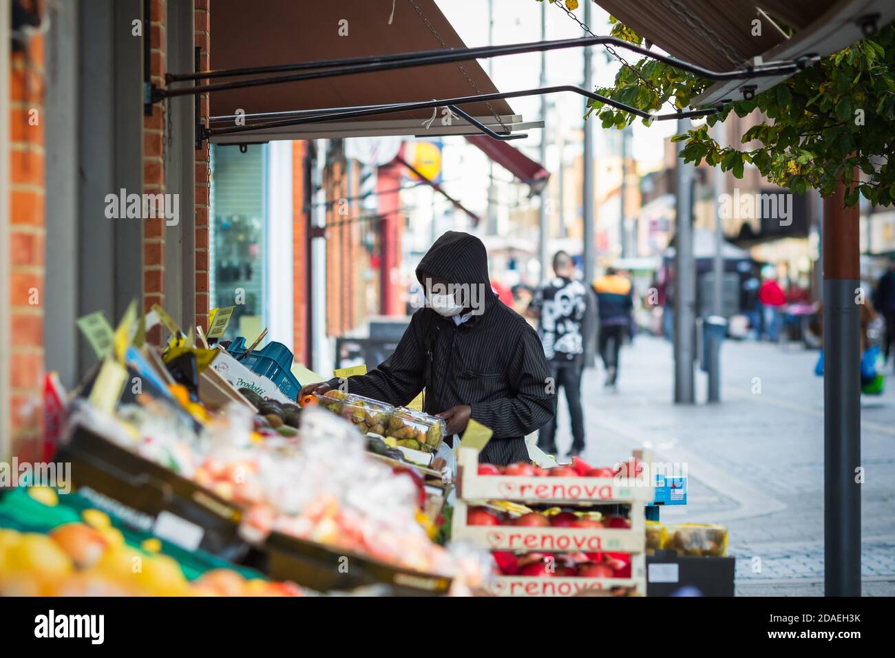 Londres, Royaume-Uni - 3 novembre 2020 - UN homme noir portant un masque facial lorsqu'il fait des achats de fruits sur le marché de Walthamstow Banque D'Images