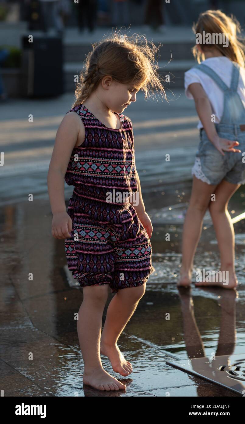 KIEV, UKRAINE - 05 juin 2018: Gaie et heureuse fille jouant dans une fontaine d'eau et appréciant les ruisseaux frais de l'eau dans une journée chaude. Été chaud. Banque D'Images