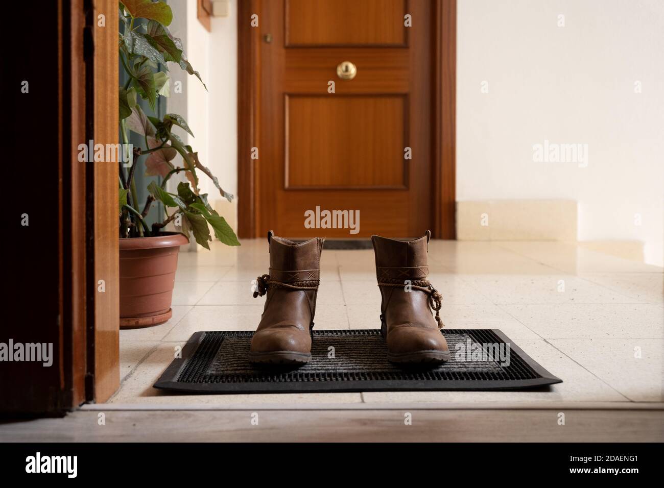 Bottes à l'entrée de la maison sur le paillasson Banque D'Images