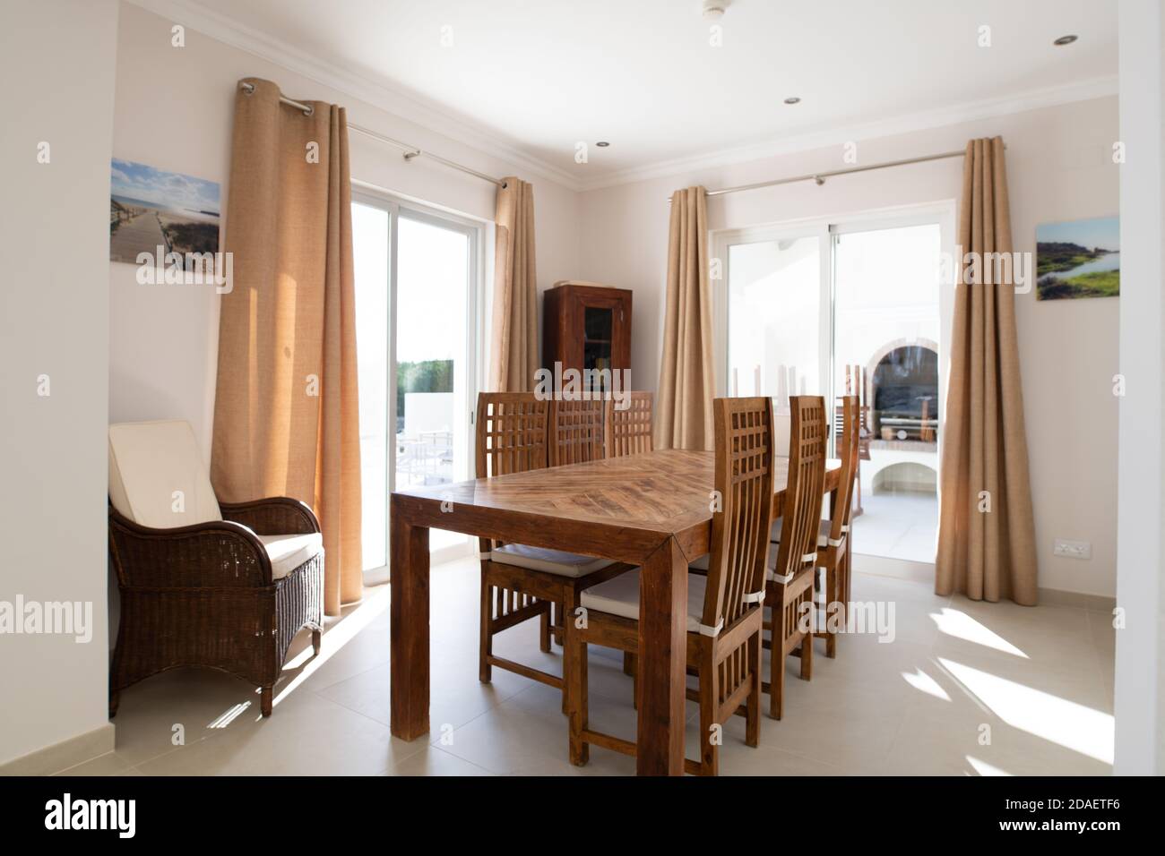 Salle à manger avec table et chaises en bois et deux ensembles de portes vitrées coulissantes Banque D'Images
