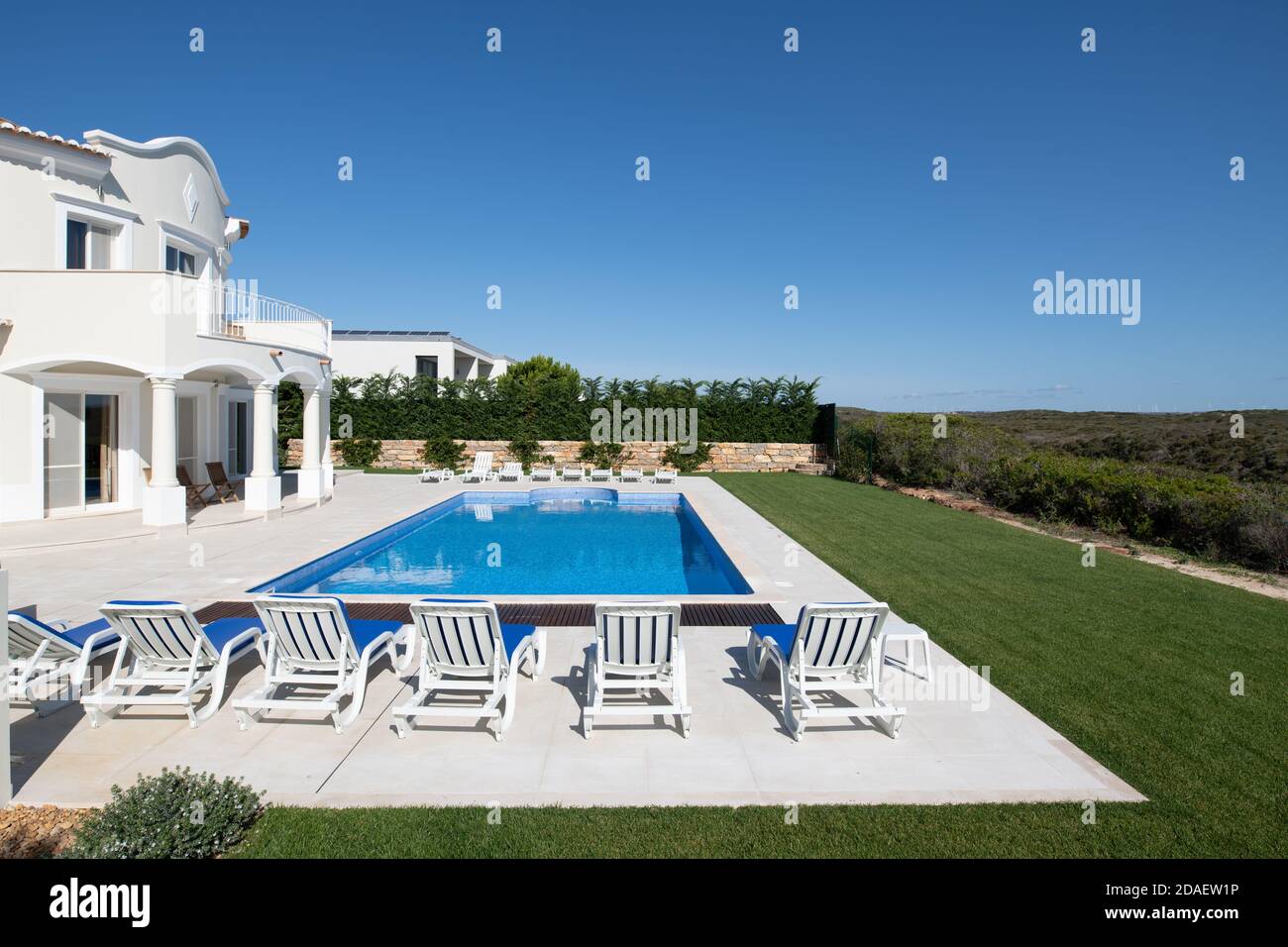 Grande piscine dans le jardin d'une villa de luxe sur l'algarve avec une rangée de chaises longues Banque D'Images