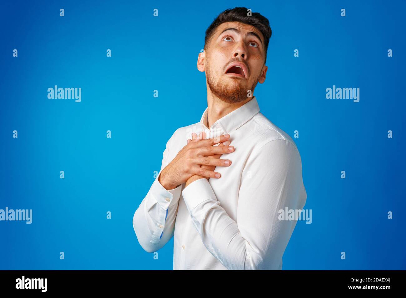 Un jeune homme barbu stupéfié et confus se présente avec étonnement. Banque D'Images