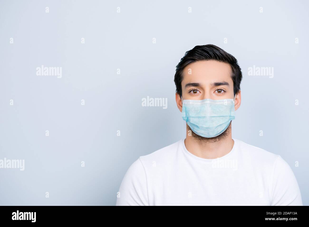 Portrait d'un homme portant un masque bleu isolé sur du blanc arrière-plan coloré avec espace vide Banque D'Images