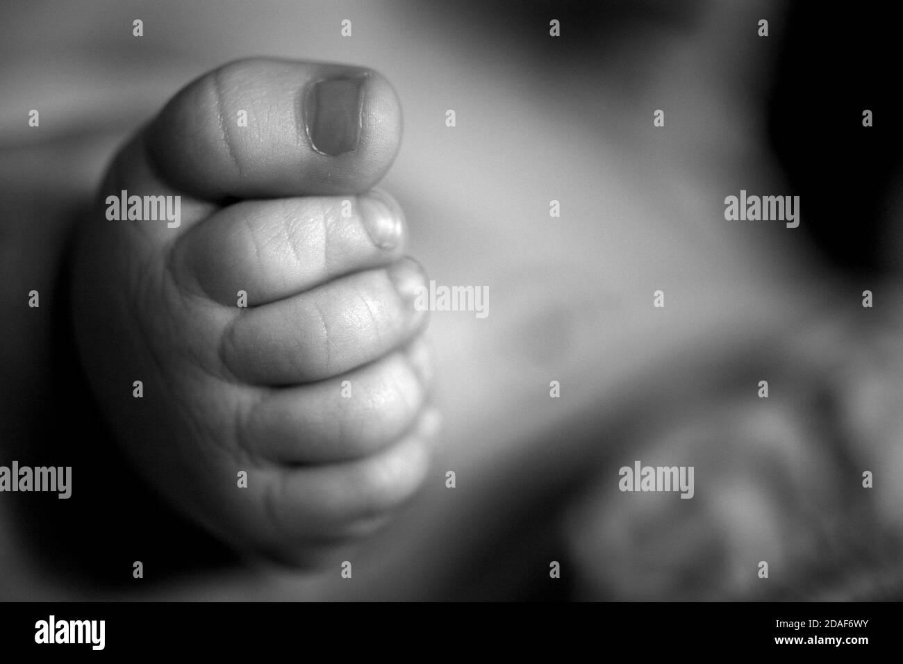 Le Pied D Un Bebe Avec Des Orteils Plies En Noir Et Blanc Photo Stock Alamy