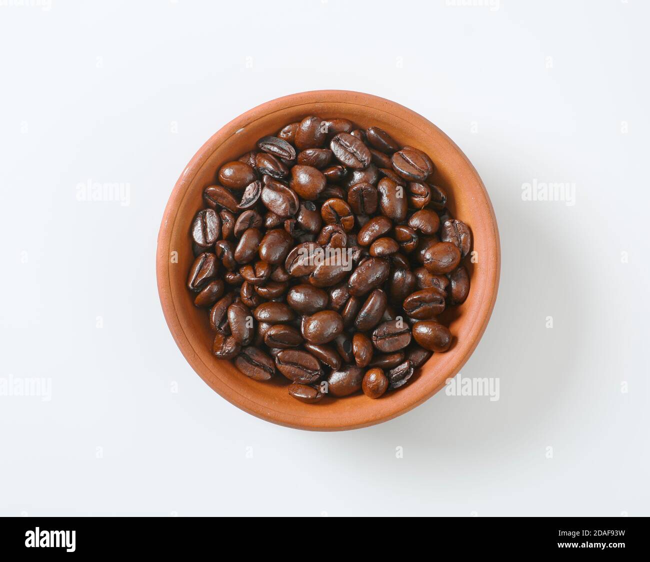 Grains de café rôtis dans un bol en terre cuite Banque D'Images Grains de café rôtis dans un bol en terre cuite Banque D'Images