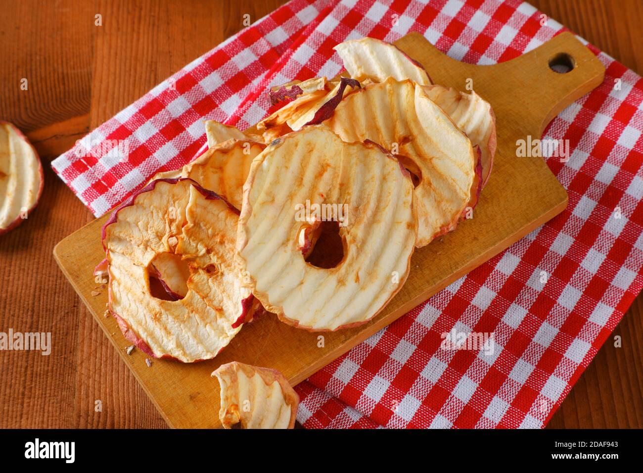 Chips de pommes séchées ou anneaux sur la planche à découper Banque D'Images Chips de pommes séchées ou anneaux sur la planche à découper Banque D'Images