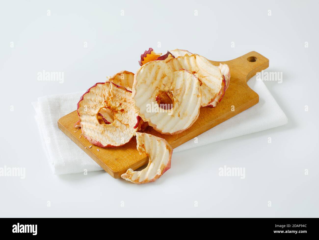 Chips de pommes séchées ou anneaux sur la planche à découper Banque D'Images Chips de pommes séchées ou anneaux sur la planche à découper Banque D'Images