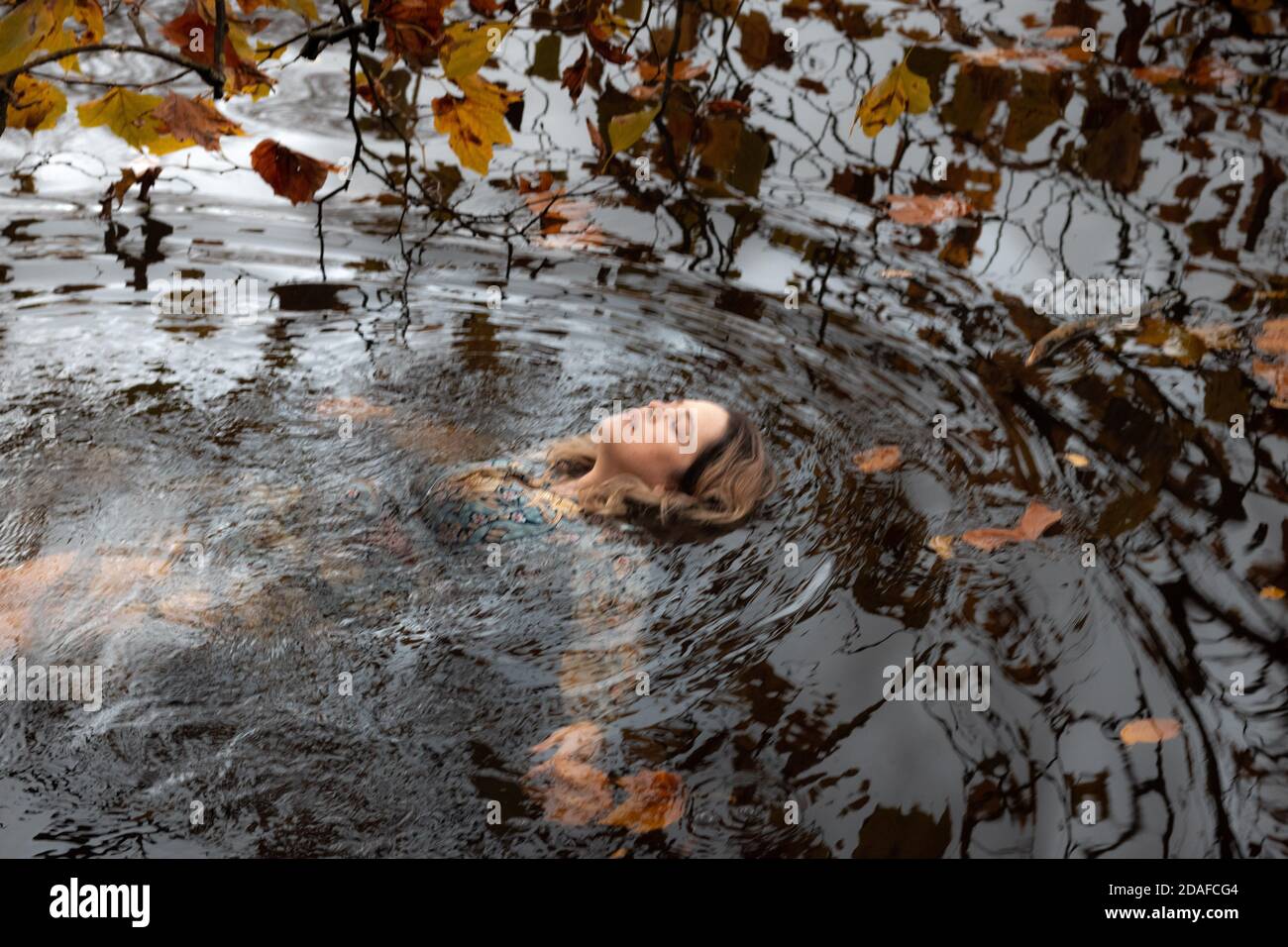 Dame portant une robe, à l'intérieur de l'eau en un jour d'automne Banque D'Images