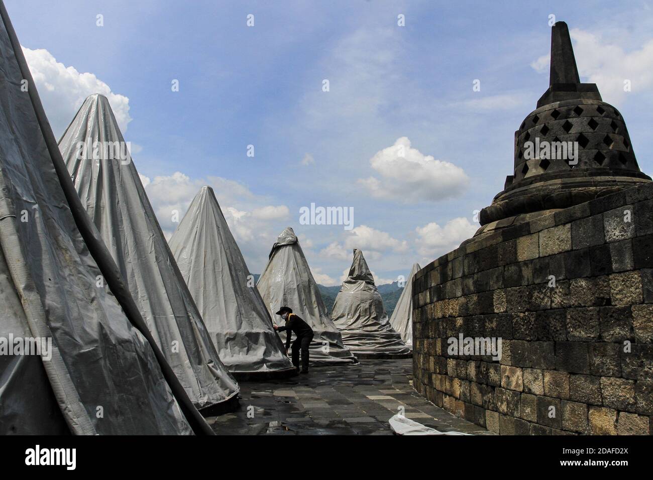 Magelang, Indonésie. 12 novembre 2020. Un ouvrier couvre la stupa au temple Borobudur avec une bâche pour prévenir une éruption volcanique anticipée du Mont Merapi à Magelang, centre de Java, Indonésie, 12 novembre 2020. Credit: Joni/Xinhua/Alay Live News Banque D'Images