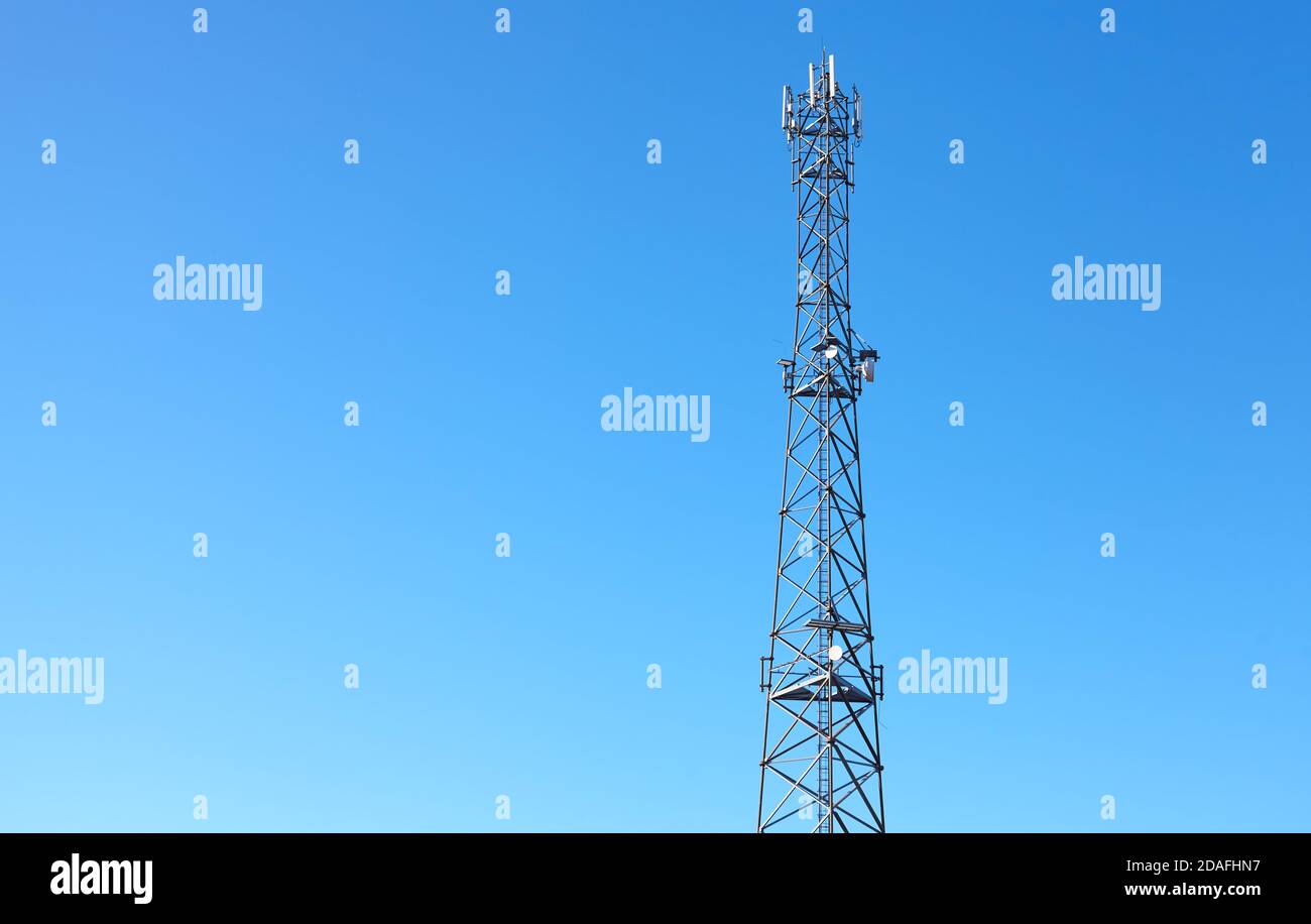 Tour de télécommunication de réseau cellulaire 3G, 4G et 5G contre le ciel bleu. Banque D'Images