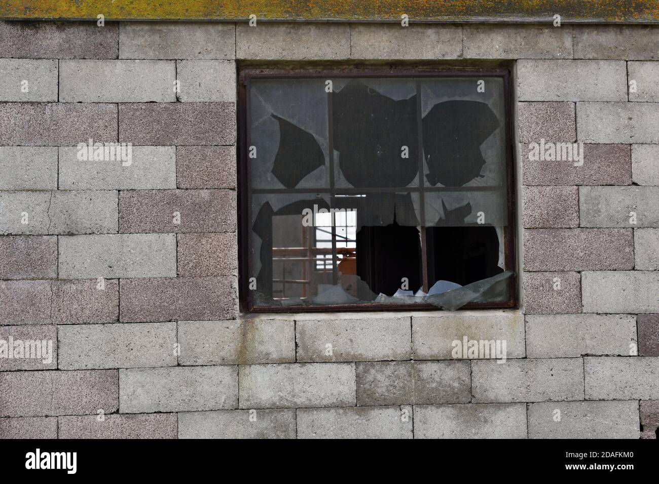 Fenêtres cassées sur un mur de briques Banque D'Images