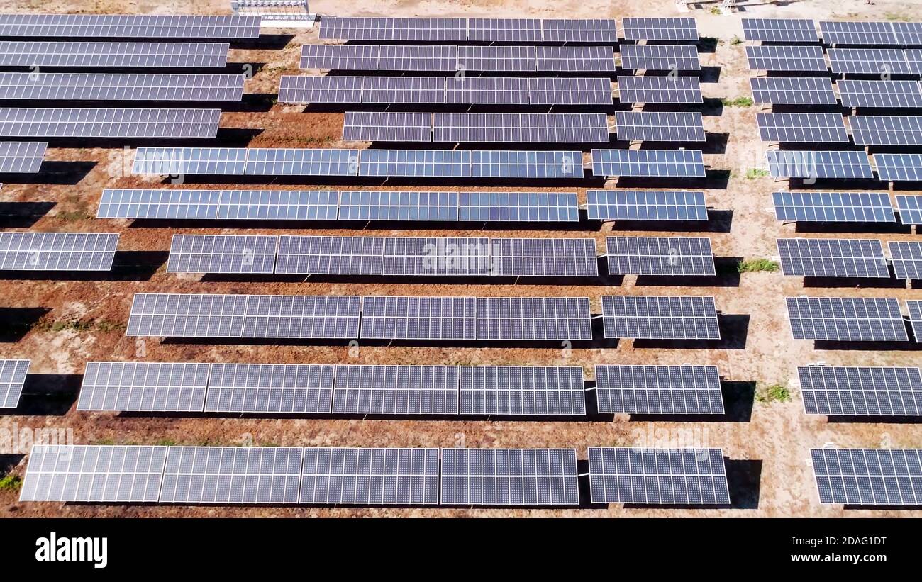 Vue aérienne d'un champ de panneaux de cellules solaires d'énergie solaire depuis le haut dans le désert. Banque D'Images