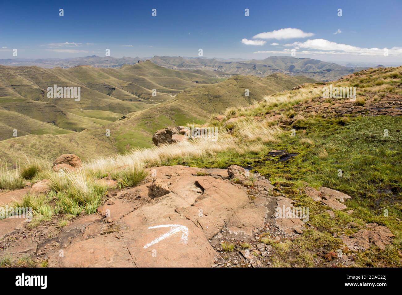 Vue sur les montagnes du Drakensberg de l'État libre, en Afrique du Sud, par une journée ensoleillée claire, avec une flèche peinte au premier plan indiquant la direction de a Banque D'Images