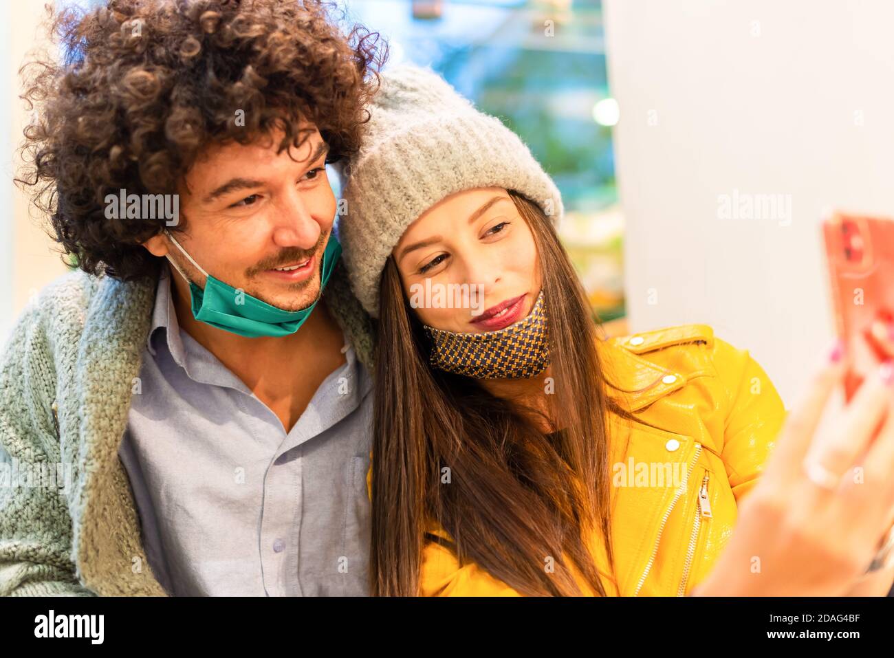 Jeunes prenant selfie intérieur portant masque de protection du visage.prévention coronavirus, Voyage sûr, tendances technologiques et automne concept de vacances. Banque D'Images