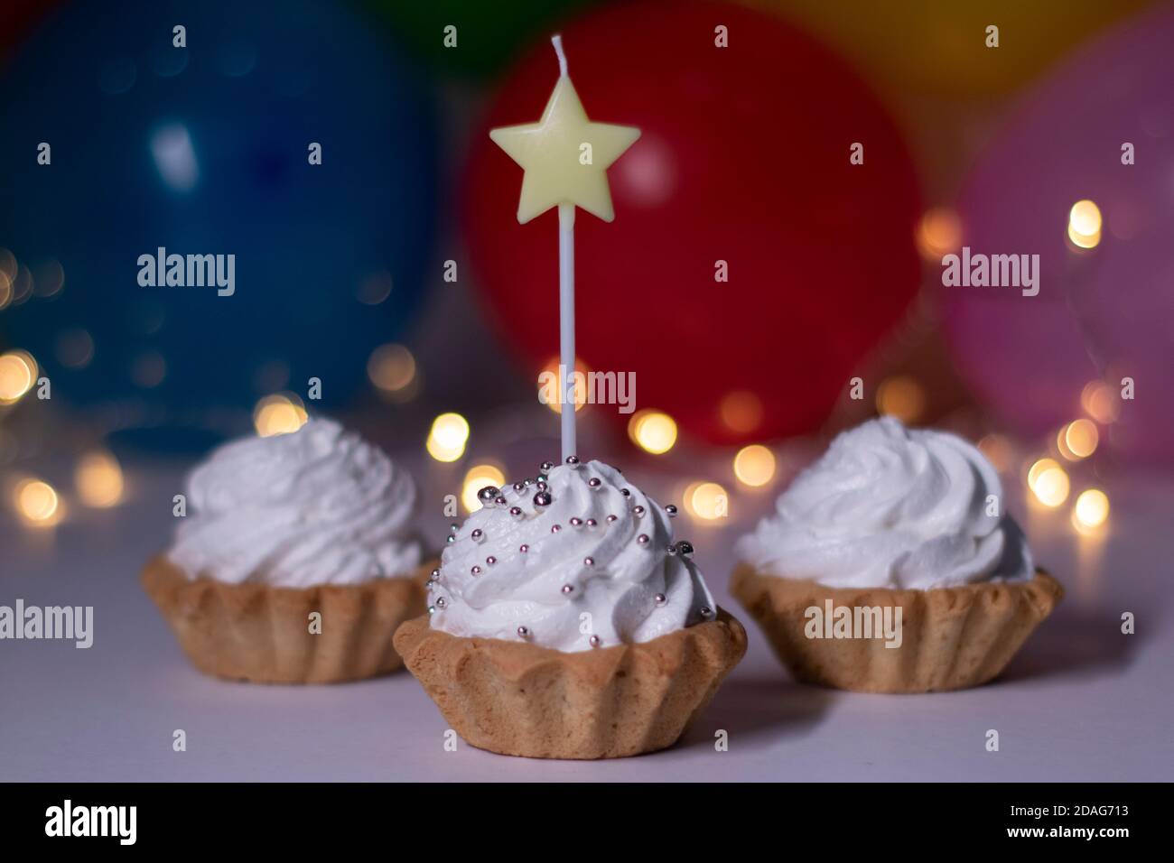 Petits Gateaux De Fete Avec Une Bougie Jaune En Forme D Etoile Sur L Arriere Plan Ballons Multicolores Et Lumieres Fete Anniversaire Concept Copier L Espace Photo De Haute Qualite Photo Stock Alamy
