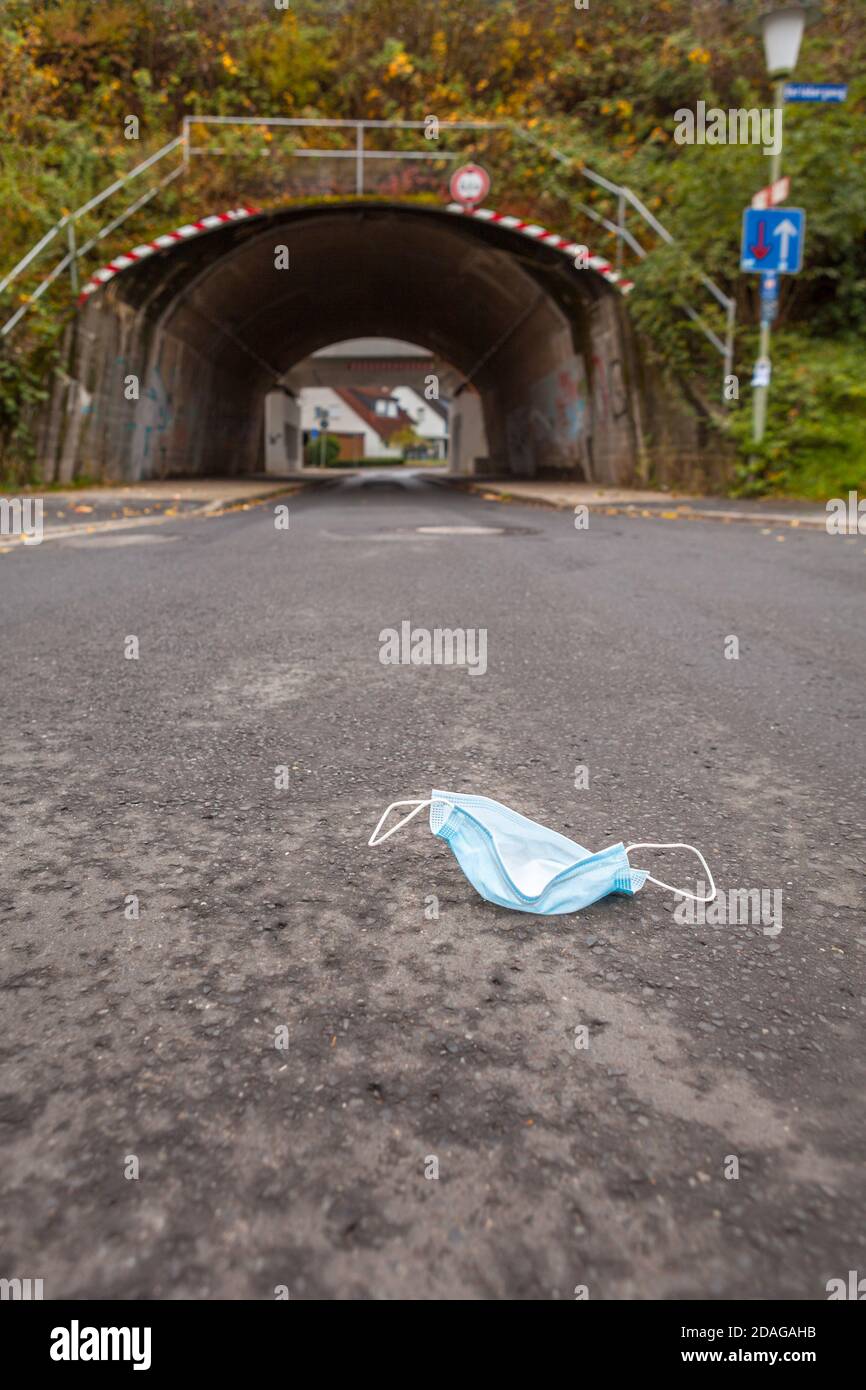 Masque de visage abandonné devant un tunnel symbolisant La pandémie Corona ou Covid-19 Banque D'Images