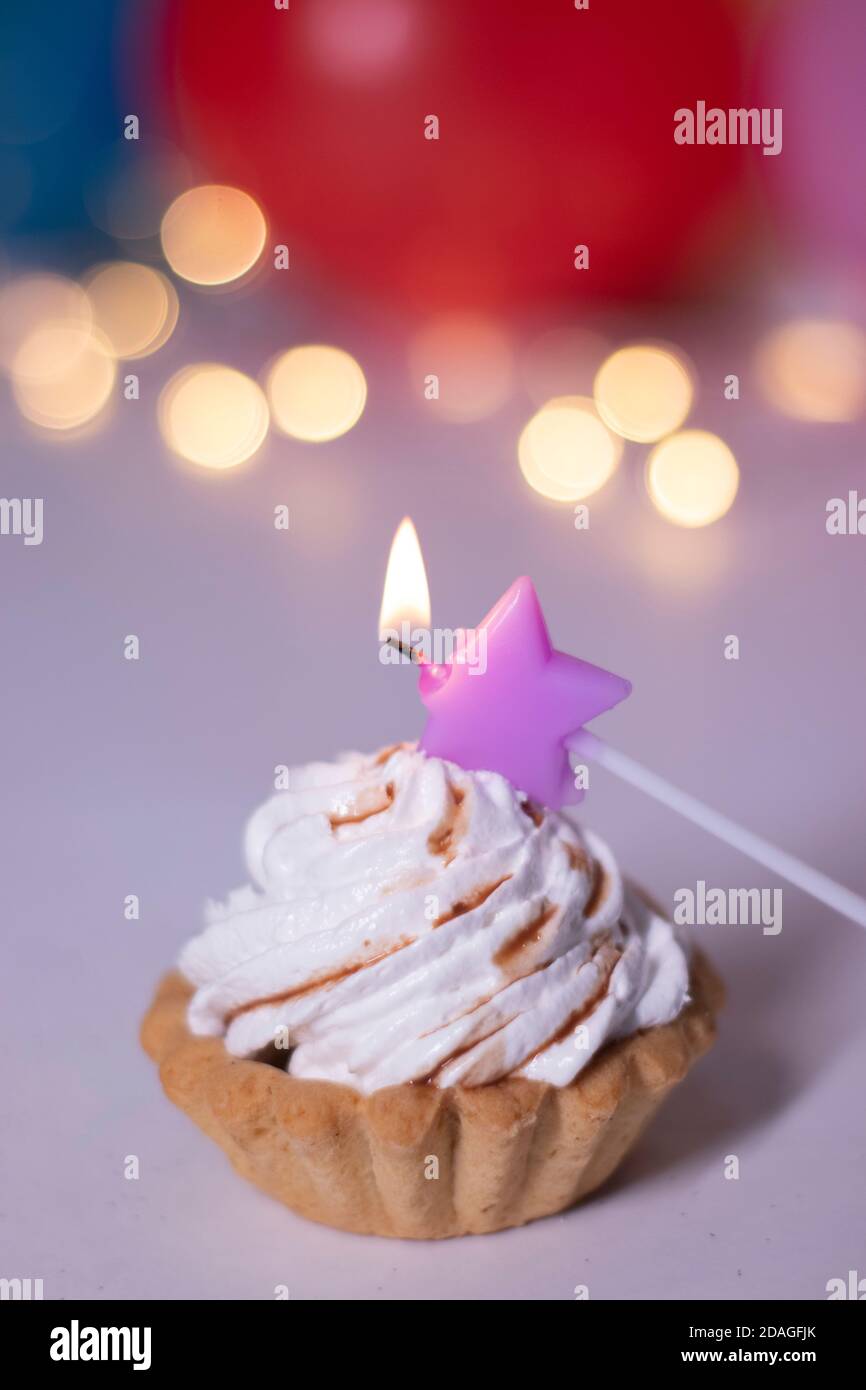 Gateau De Fete Avec Une Bougie En Forme D Etoile Violette Sur Fond De Boite Cadeau Rouge Avec Ruban Rose Ballons Multicolores Et Lumieres Fete Concept Anniversaire Copier L Espace Photo De Haute