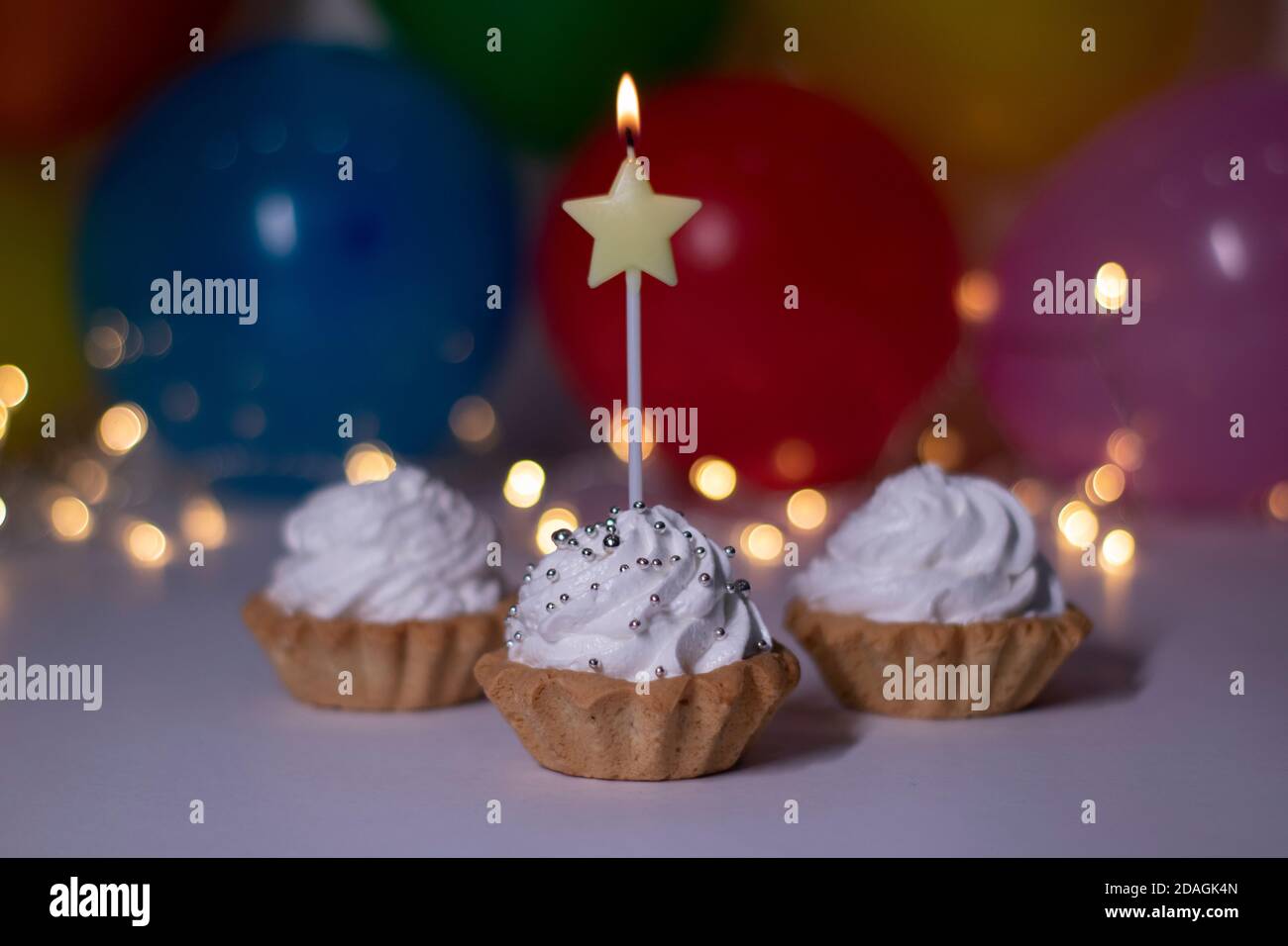Petits Gateaux De Fete Avec Une Bougie Jaune En Forme D Etoile Sur L Arriere Plan Ballons Multicolores Et Lumieres Fete Anniversaire Concept Copier L Espace Photo De Haute Qualite Photo Stock Alamy