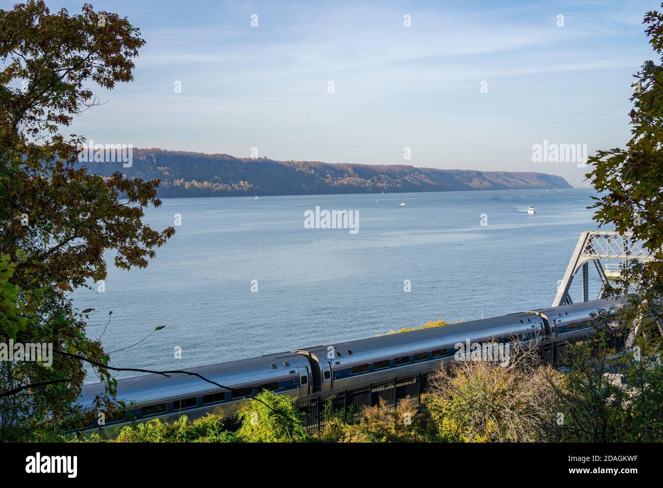 Train Amtrak longeant la rivière Hudson avec quelques bateaux sur l'eau Banque D'Images