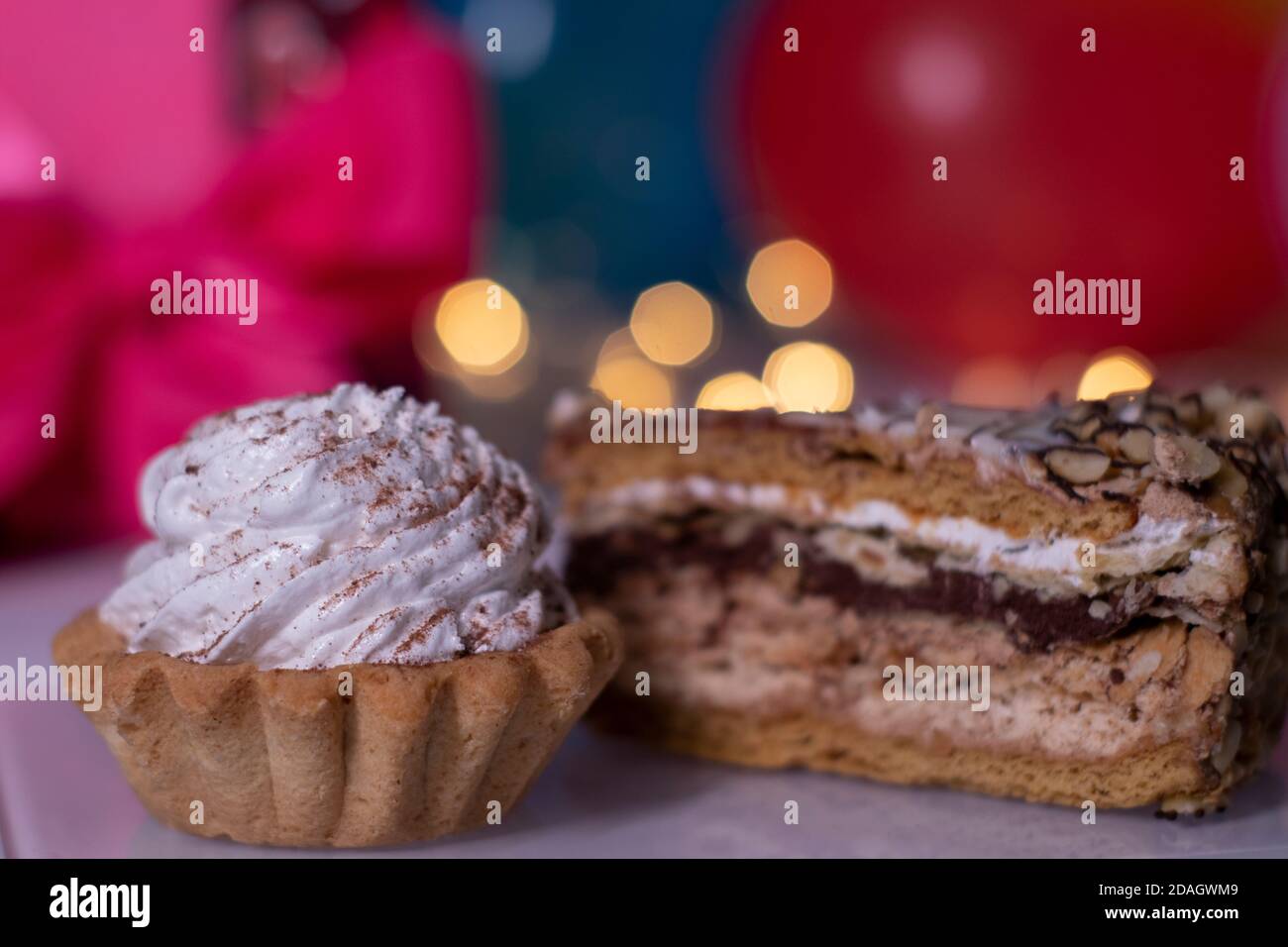 Gateau De Fete Avec Une Bougie Jaune En Forme D Etoile Sur Fond De Boite Cadeau Rouge Avec Ruban Rose Ballons Multicolores Et Lumieres Fete Concept Anniversaire Copier L Espace Photo De Haute