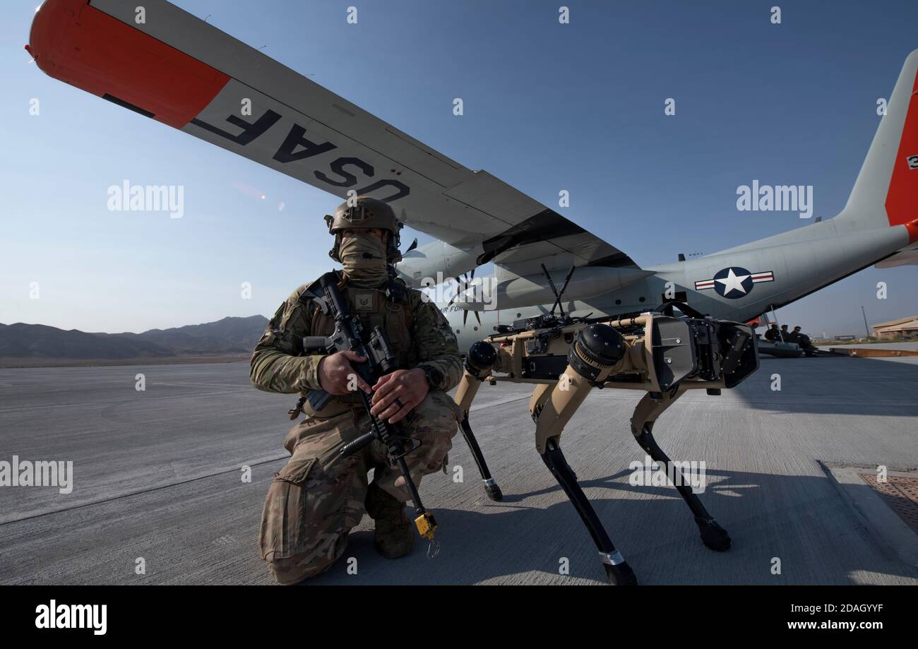 U.S. Air Force Tech. Sgt. Johnny Rodriguez assure la sécurité sur la ligne de vol le long du véhicule au sol sans pilote Ghost Q-UGV, connu sous le nom de chien robotique, lors d'un exercice de système avancé de gestion de combat à la base aérienne de Nellis le 1er septembre 2020 à Las Vegas, Nevada. Banque D'Images