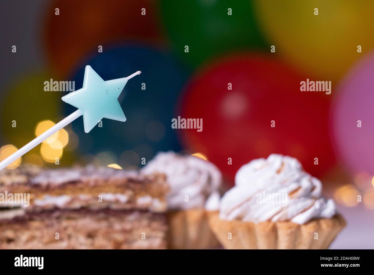 Gateau De Fete Avec Une Bougie En Forme D Etoile Bleue Sur Fond De Ballons Multicolores Et De Lumieres Concept Fete Anniversaire Copier L Espace Photo De Haute Qualite Photo Stock Alamy