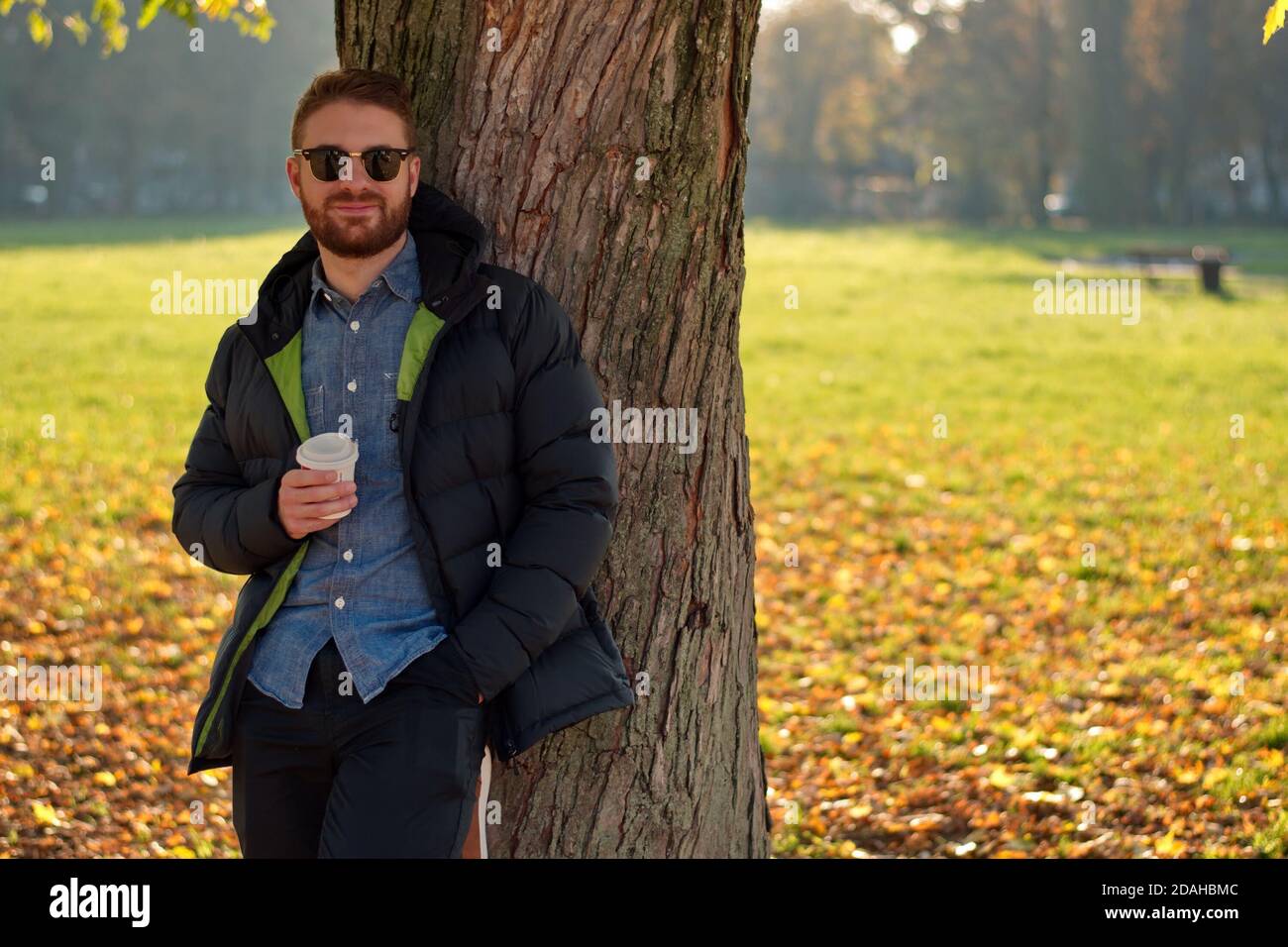 Portrait de beau jeune homme dans le parc - paysage d'automne Banque D'Images