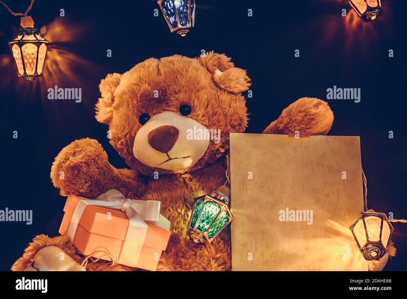 Carte de Noël avec cadeaux à motif ours en peluche et guirlande de lumières de fées. Banque D'Images
