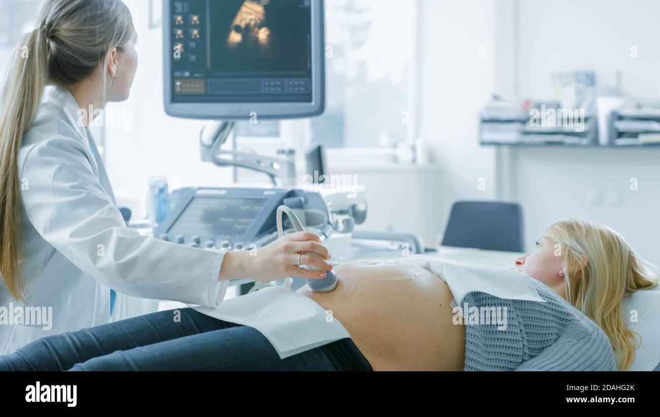 À l'hôpital, la femme enceinte se fait acquérir un échographe, l'obstétricien vérifie l'image du bébé en bonne santé sur l'écran de l'ordinateur Banque D'Images