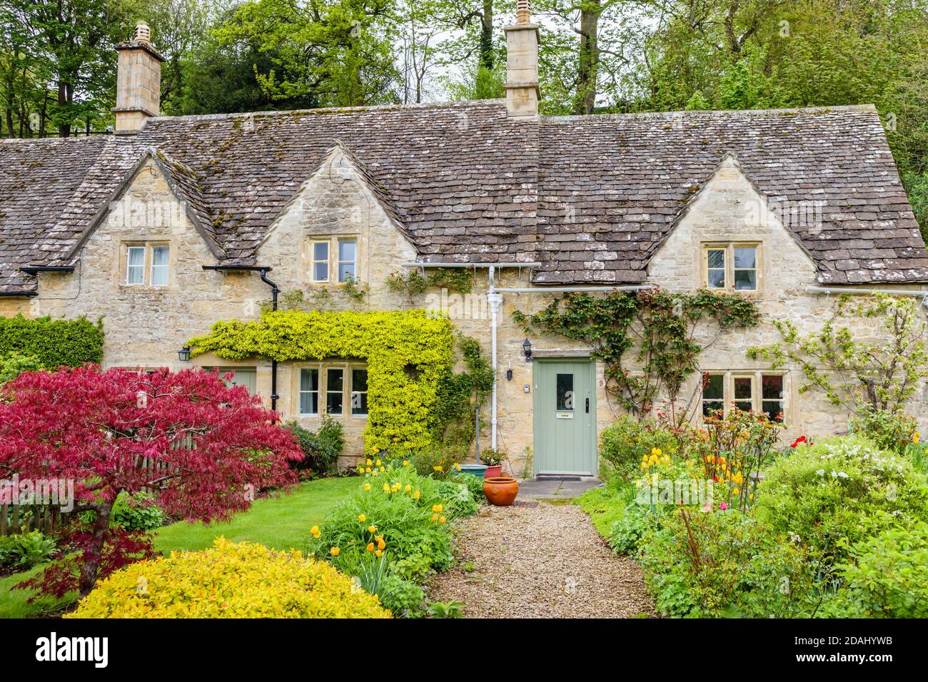 Cotswold traditionnel belles maisons mitoyennes en pierre et jardins à l'avant Le village de Bibury dans les Cotswolds de Gloucestershire Banque D'Images