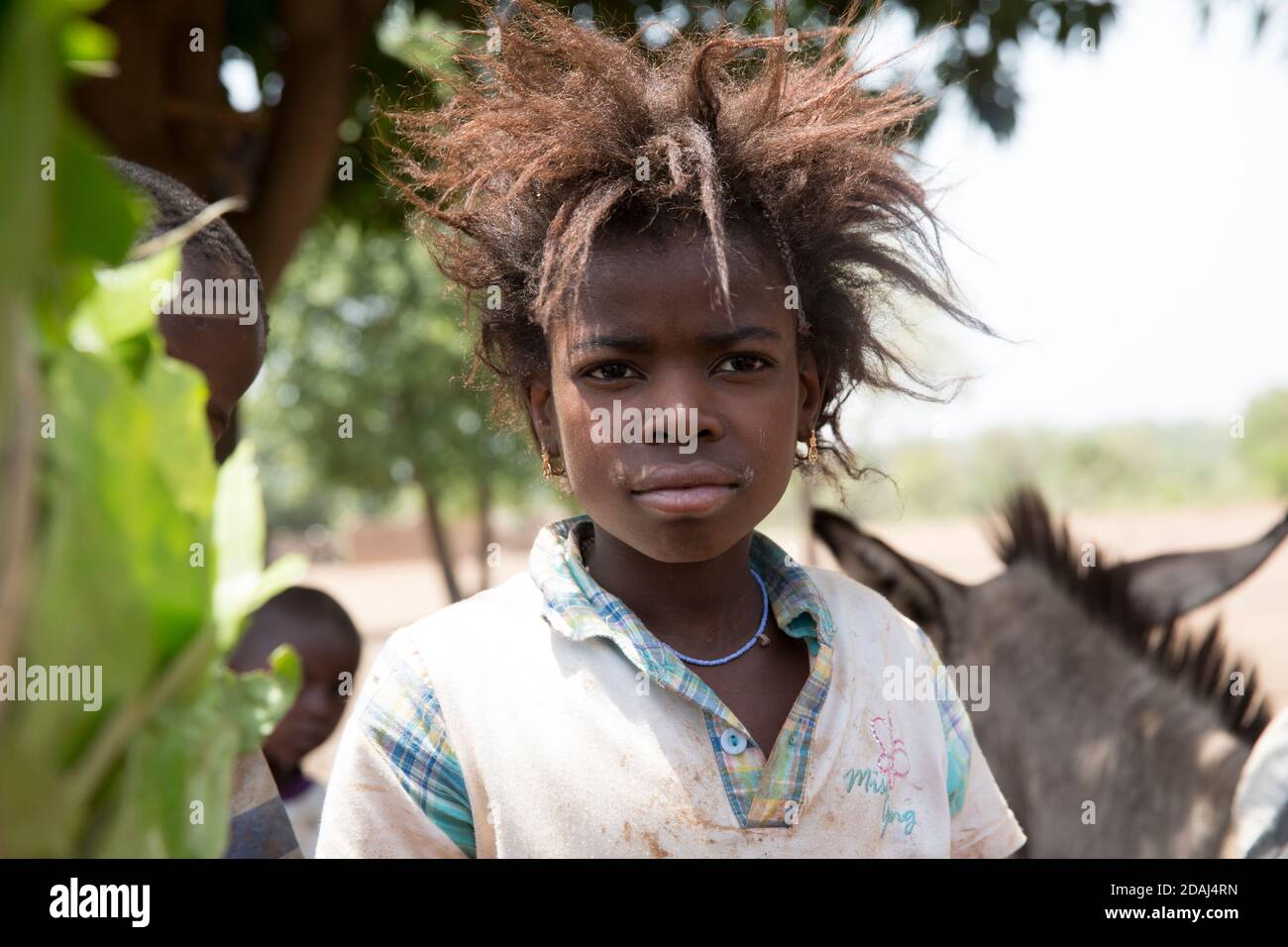 Selingue, Mali, le 25 avril 2015; UNE jeune fille regardant le vendeur de charbon de bois décharger ses sacs. Banque D'Images